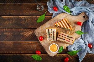 club sandwich avec jambon, tomate, fromage et épinards. panini grillé. vue de dessus photo