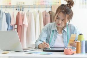 vêtements de créateur de jeune femme, espace de travail de créateur de vêtements, accessoires de conception de vêtements. photo