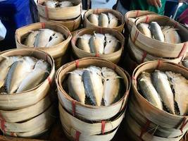 Poissons maquereaux cuits à la vapeur thaïlandais dans un panier en bambou à vendre sur le marché. photo