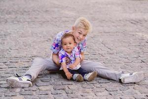 caucasien adorables garçons mignons frères et sœurs se tenant les uns les autres en journée ensoleillée en plein air. famille, aide, concept de soutien photo