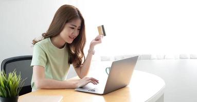 paiement en ligne woman's hands holding a credit card and using laptop computer for online shopping photo