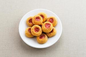 biscuits à empreinte de pouce remplis de confiture de fraises et de fromage râpé. familier pendant le mois de ramadan et eid fitri. photo