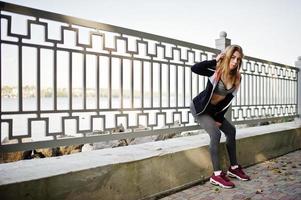 la jeune fille a la formation et fait de l'exercice à l'extérieur. sport, fitness, concept d'entraînement de rue. photo