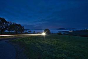 route avec arbres et prairies à l'heure bleue le soir photo