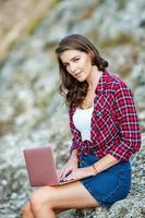 bureau à l'extérieur. belle fille travaille sur un ordinateur portable en plein air. femme indépendante. concept de travailleur indépendant. photo