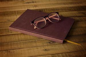 livre avec des lunettes sur le fond en bois photo