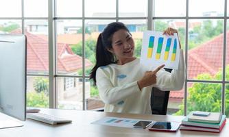 travail à domicile et concept d'apprentissage ou de réunion en ligne. jolies jeunes femmes travaillant sur ordinateur à l'aide d'un smartphone dans le salon ou l'espace de co-working. cours de formation en ligne pour étudiants. photo