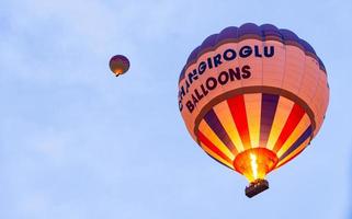 goreme, turke, 2019- touristes chevauchant la montgolfière colorée qu'il survole goreme, paysage de cappadoce photo