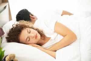 notion d'amant. jeune couple séduisant allongé sous une couverture blanche au lit photo
