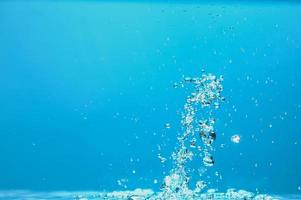 image de fond abstrait de bulles dans l'eau. eau propre avec des gouttelettes d'eau et des vagues. eau douce un verre avec fond bleu bulles. photo