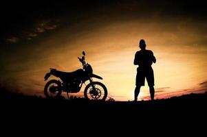 silhouettes masculines et vélos de motocross de tourisme. parc pour se détendre à la montagne le soir. concept de voyage d'aventure et de loisirs photo