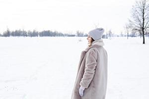 jeune fille en vêtements beiges, manteau de fourrure en fourrure artificielle se promène en hiver photo