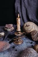 bougie allumée et pierres sur la table de la sorcière. concept occulte, ésotérique. photo