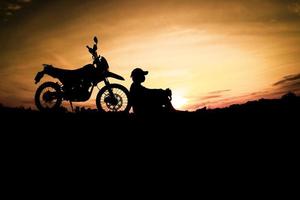 silhouettes masculines et vélos de motocross de tourisme. parc pour se détendre à la montagne le soir. concept de voyage d'aventure et de loisirs photo