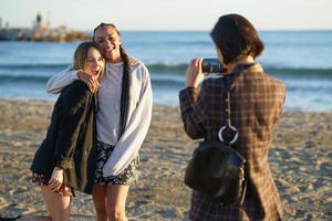 femme sans visage photographiant diverses copines positives près de la mer photo