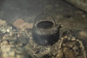 la bouilloire repose sur des charbons. cuisine dans la nature. détails du pique-nique. photo