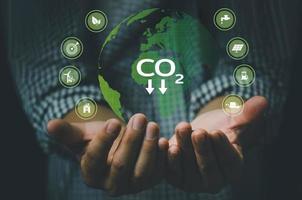 émissions de carbone main green globe et protection de l'environnement, l'avenir utilise la technologie des ressources pour réduire la pollution. photo