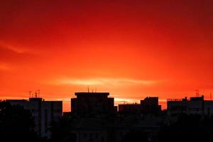 silhouette de la ville au coucher du soleil. le soleil se lève sur de grands immeubles. photo