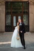 le marié en costume marron et la mariée en robe blanche photo