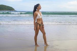 belle jeune femme en bikini profitant et se relaxant sur la plage, l'été, les vacances, les vacances, le concept de modes de vie. photo