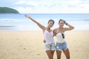 deux jolies amies appréciant et se relaxant sur la plage, l'été, les vacances, les vacances, le concept de modes de vie. photo