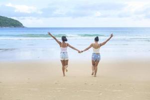 deux jolies amies appréciant et se relaxant sur la plage, l'été, les vacances, les vacances, le concept de modes de vie. photo