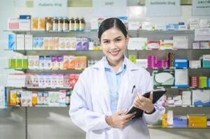 portrait d'une pharmacienne à l'aide d'une tablette dans une pharmacie de pharmacie moderne. photo