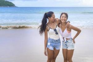 deux jolies amies appréciant et se relaxant sur la plage, l'été, les vacances, les vacances, le concept de modes de vie. photo