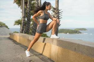 portrait d'une belle femme en forme de vêtements de sport sur le sommet de la montagne en bord de mer, concept de santé et de voyage. photo