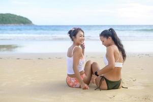 deux jolies amies en bikini s'amusant et se relaxant sur la plage, l'été, les vacances, les vacances, le concept de modes de vie. photo