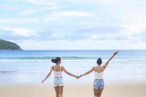 deux jolies amies appréciant et se relaxant sur la plage, l'été, les vacances, les vacances, le concept de modes de vie. photo