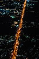 vue nocturne depuis l'avion à réaction au crépuscule avec le ciel rouge et la lumière de la ville. photo