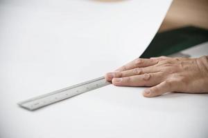 homme utilisant un outil à main de mesure faisant des travaux de coupe de papier peint dans un chantier de construction de maisons, des personnes avec un concept d'objet d'outil à main photo