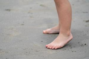 fermez les jambes des enfants, jouez et apprenez à la plage. photo