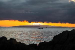 mer de thaïlande au crépuscule avec bateau silhouette et pêcheur dans la mer photo