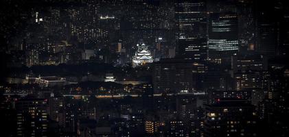 château d'osaka illuminé la nuit en panorama à vol d'oiseau ou vue de dessus avec paysage urbain et haut bâtiment autour, préfecture d'osaka, japon. photo