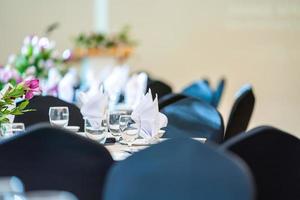 déjeuner ou dîner de luxe sur le modèle de table longue avec une table de couverture noire avec décoration florale. photo