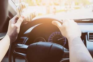 homme mangeant des beignets en conduisant une voiture - concept de conduite dangereuse multitâche photo