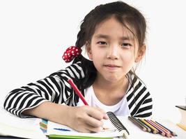 une jolie fille fait ses devoirs, colorie ou dessine un livre photo