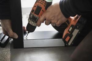 homme faisant un cadre en aluminium avec des lunettes et des travaux d'installation de portes et fenêtres à moustiquaire sur le chantier de construction photo