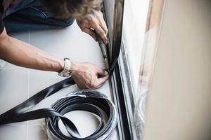 homme faisant un cadre en aluminium avec des lunettes et des travaux d'installation de portes et fenêtres à moustiquaire sur le chantier de construction photo