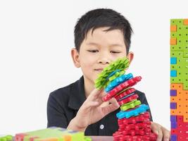 les enfants asiatiques jouent à un jeu créatif de bloc de puzzle en plastique pour pratiquer leurs compétences physiques et mentales photo
