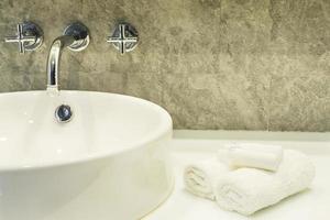 Lavabo de la salle de bain avec set de nettoyage blanc dans un hôtel