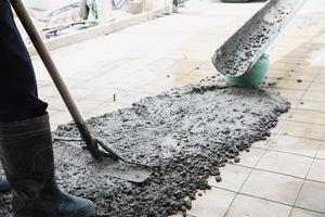 ouvrier faisant un travail de coulée de béton au sol sur un chantier de construction photo