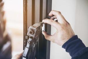 homme faisant un cadre en aluminium avec des lunettes et des travaux d'installation de portes et fenêtres à moustiquaire sur le chantier de construction photo