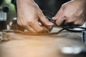 le charpentier travaille avec l'assemblage de meubles à l'aide d'un tournevis électrique - travail de technicien sur place à l'aide du concept d'outils à main photo