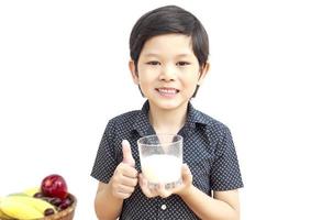 garçon asiatique boit un verre de lait sur fond blanc photo