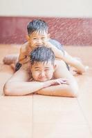 les enfants jouent joyeusement avec de l'eau pulvérisée pendant la saison chaude photo