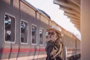 l'homme de voyage attend le train à la gare, chiangmai, thaïlande, 23 mai 2019 photo