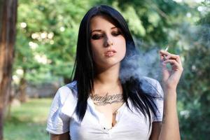 belle jeune fille avec un tatouage fume photo